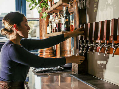 inkeeper pours beer from a tap at Copper Vine Pub in New Orleans