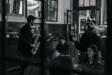 man plays saxophone in a crowded pub at the copper vine in new orleans