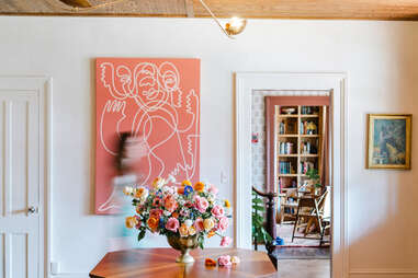 woman walks past art through the lobby at The Henson in the Catskills